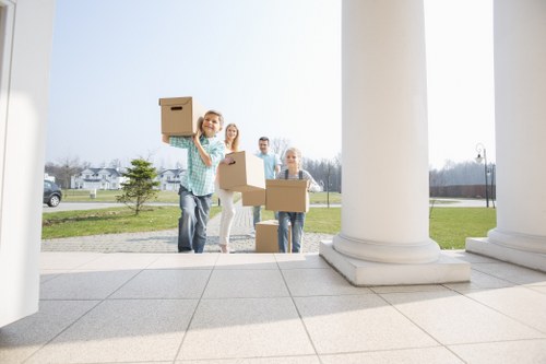 Professional movers handling boxes and furniture in a South London flat
